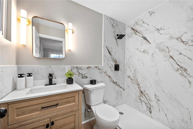 bathroom featuring vanity, tiled shower, tile walls, and toilet