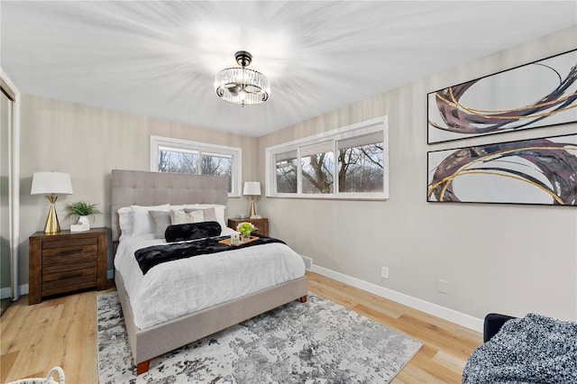 bedroom featuring a chandelier and light hardwood / wood-style floors