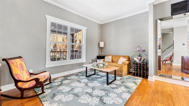 sitting room with ornamental molding and hardwood / wood-style floors