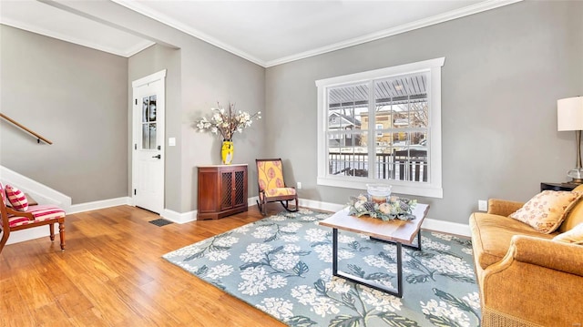 living area with wood-type flooring and ornamental molding