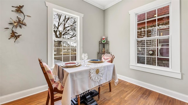 dining room with ornamental molding and hardwood / wood-style flooring