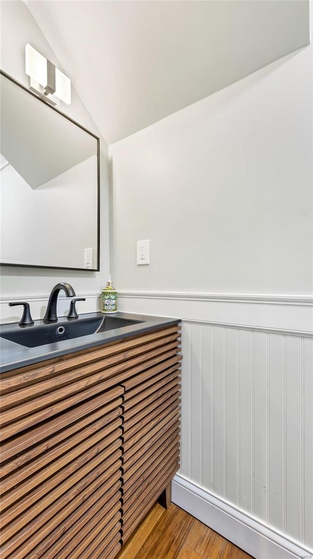 bathroom with vaulted ceiling, hardwood / wood-style flooring, and vanity