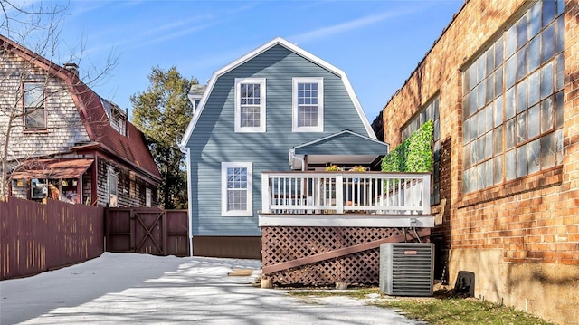 back of property with central AC unit and a wooden deck