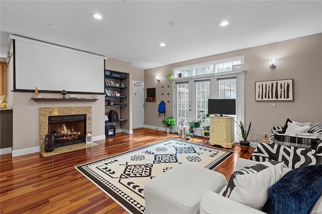 living room with wood-type flooring and a tile fireplace