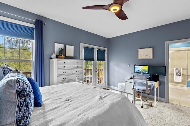 carpeted bedroom featuring ensuite bathroom, ceiling fan, and french doors