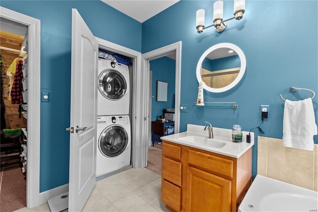 laundry room with light tile patterned floors, stacked washer / drying machine, and sink