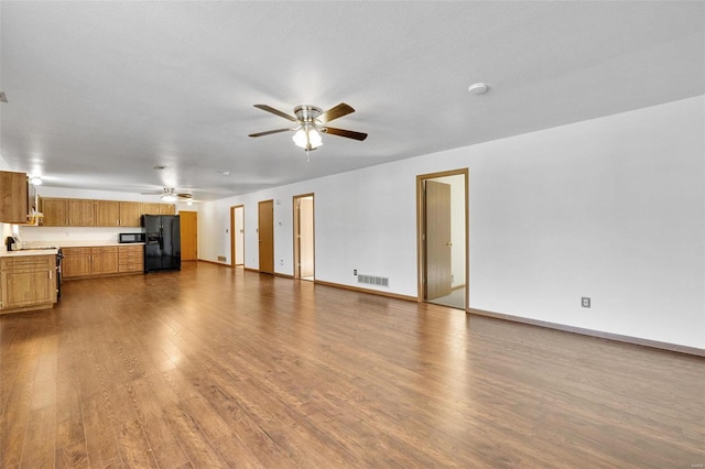 unfurnished living room with hardwood / wood-style flooring, a textured ceiling, and ceiling fan