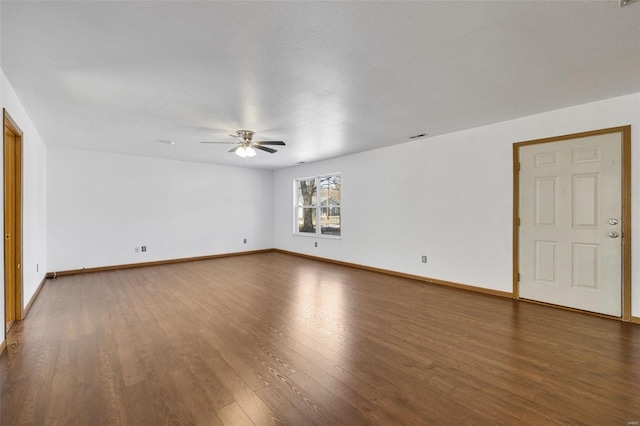 empty room with ceiling fan, a textured ceiling, and dark hardwood / wood-style flooring