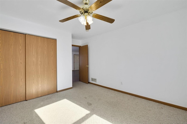 unfurnished bedroom with light carpet, a closet, and ceiling fan