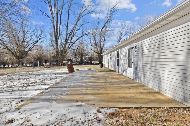 snowy yard with a patio