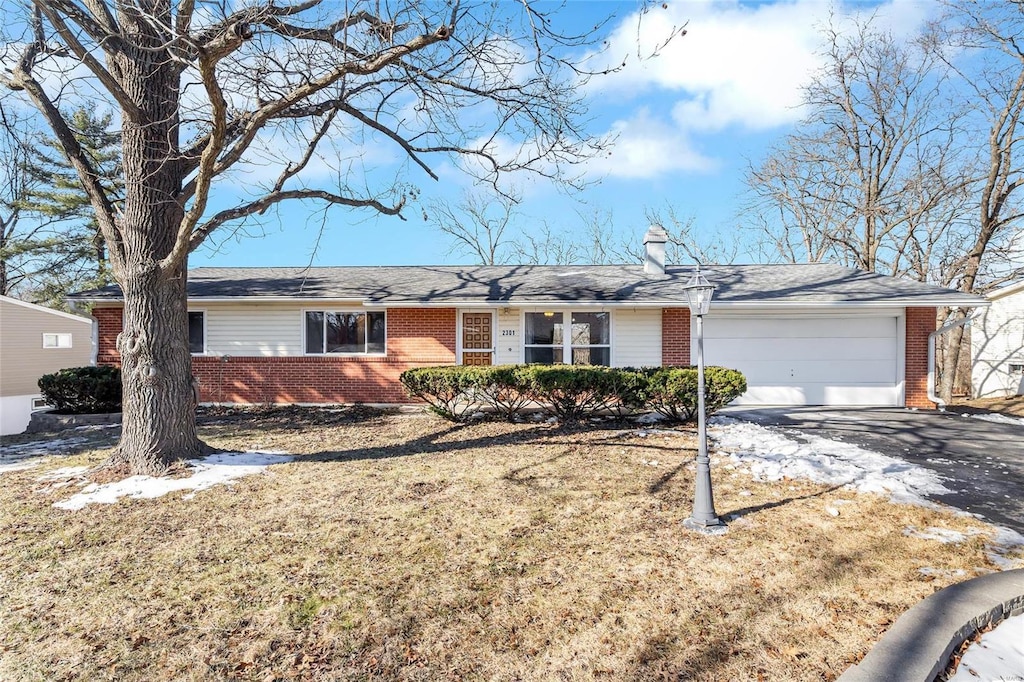 ranch-style house featuring a garage and a front lawn