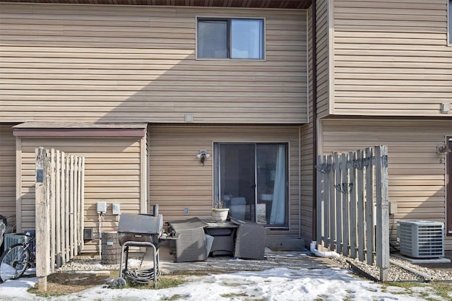 snow covered rear of property with central AC