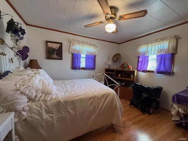 bedroom featuring ceiling fan, ornamental molding, and hardwood / wood-style flooring