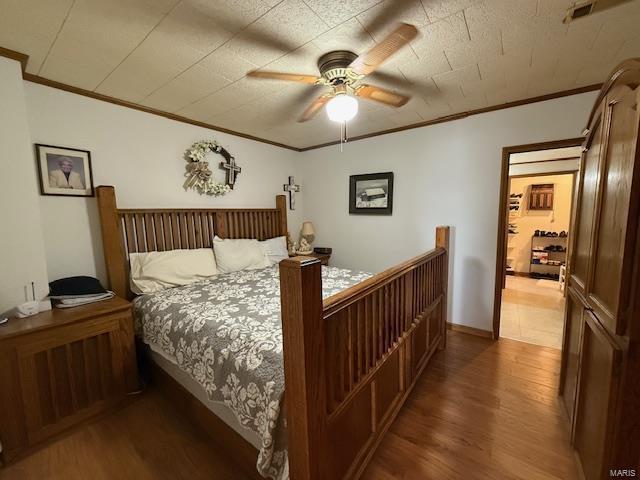 bedroom featuring crown molding, dark hardwood / wood-style floors, and ceiling fan