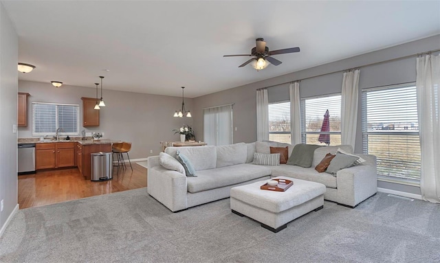 carpeted living room featuring ceiling fan and sink