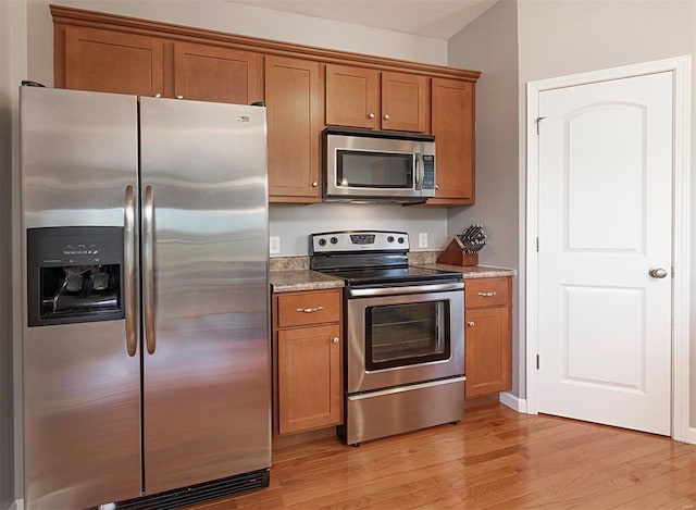 kitchen with light hardwood / wood-style floors and appliances with stainless steel finishes