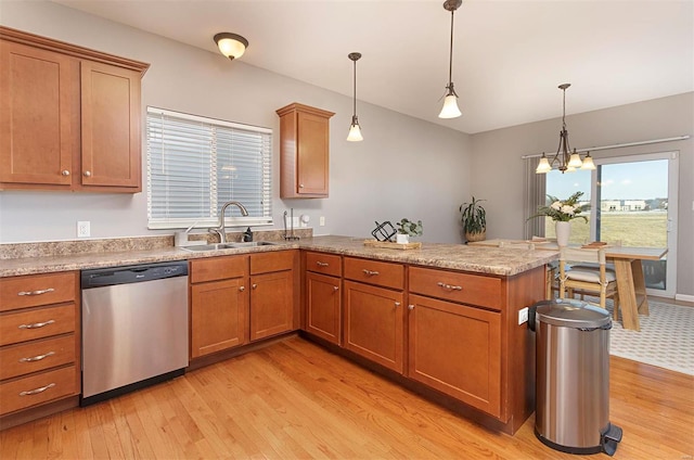 kitchen with pendant lighting, sink, kitchen peninsula, light wood-type flooring, and stainless steel dishwasher