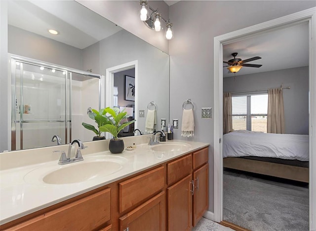 bathroom featuring ceiling fan, a shower with shower door, and vanity