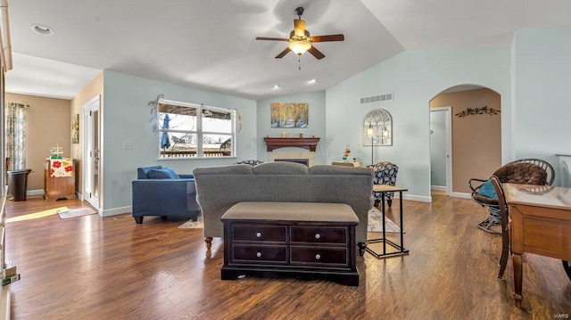 living room with ceiling fan, dark hardwood / wood-style floors, and vaulted ceiling