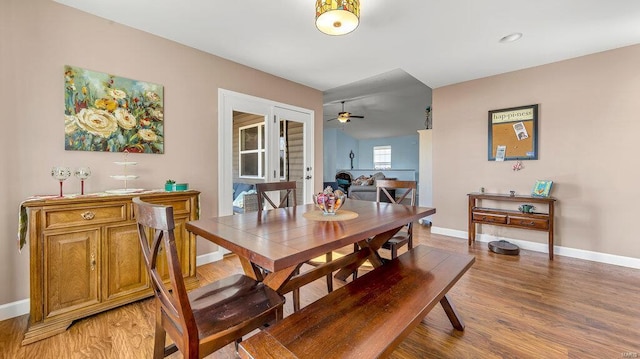 dining space with wood-type flooring, ceiling fan, and french doors