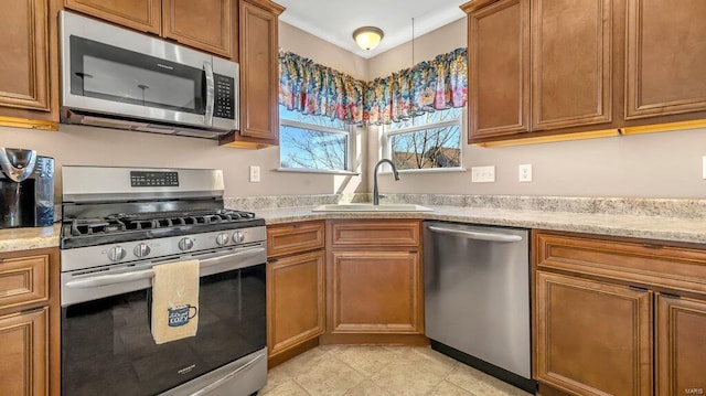 kitchen featuring sink, light stone countertops, and appliances with stainless steel finishes