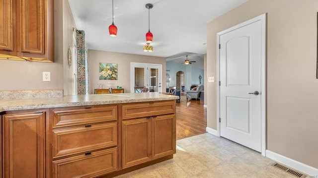 kitchen featuring decorative light fixtures, ceiling fan, and french doors