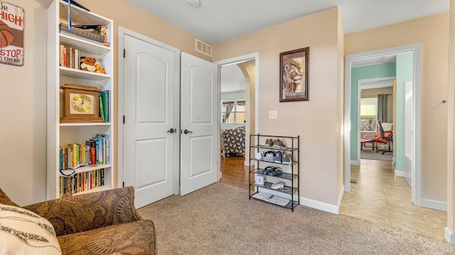 living area featuring light carpet