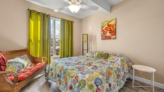 bedroom with ceiling fan, beam ceiling, and dark hardwood / wood-style flooring