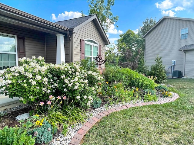 view of property exterior with central air condition unit and a lawn