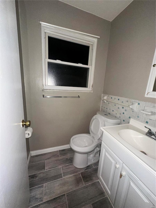 bathroom featuring vanity, toilet, and decorative backsplash