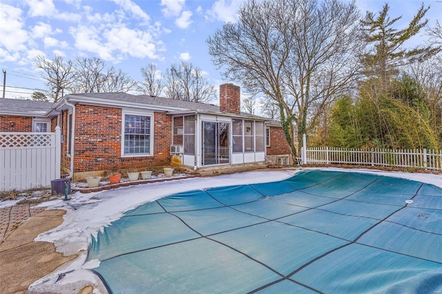 view of swimming pool featuring a sunroom