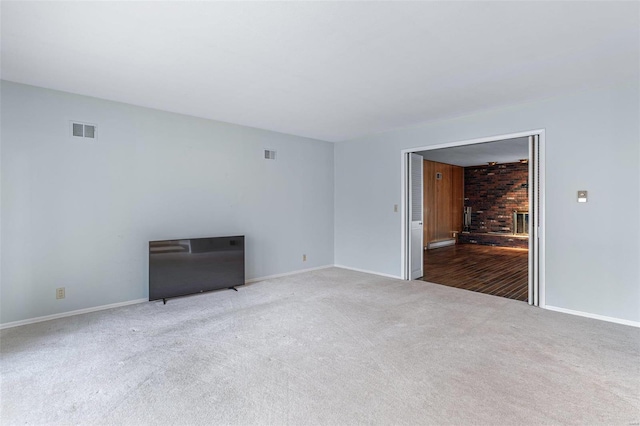 unfurnished room with a brick fireplace and light carpet