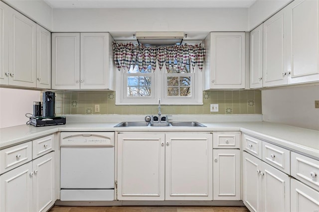 kitchen with tasteful backsplash, dishwasher, sink, and white cabinets