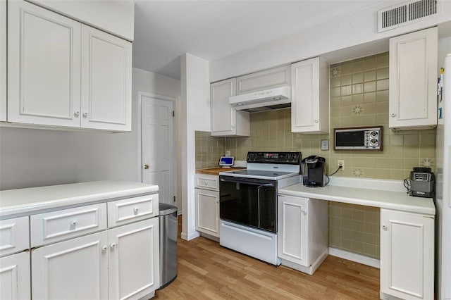 kitchen featuring white cabinetry, light hardwood / wood-style floors, decorative backsplash, and range with electric stovetop