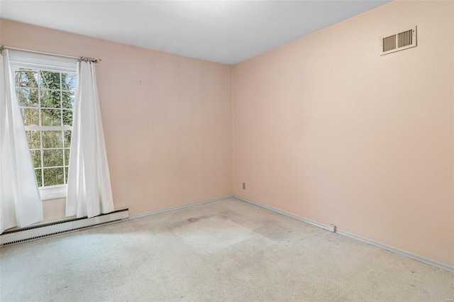 spare room with a baseboard radiator and light colored carpet