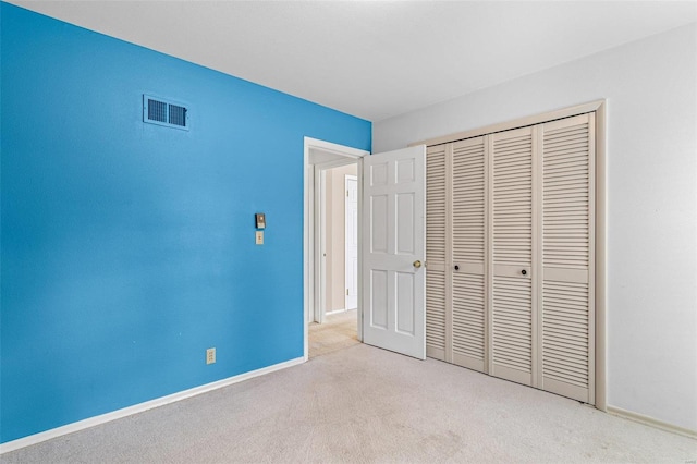 unfurnished bedroom with light colored carpet and a closet