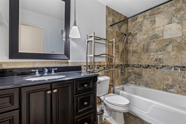 full bathroom featuring tiled shower / bath, tile walls, vanity, and toilet