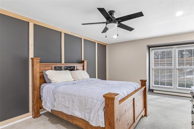 bedroom with a baseboard heating unit, light carpet, and ceiling fan