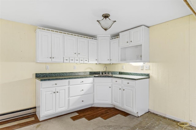 kitchen featuring sink, white cabinets, and baseboard heating