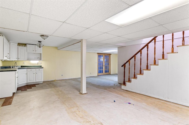 basement featuring a paneled ceiling and sink