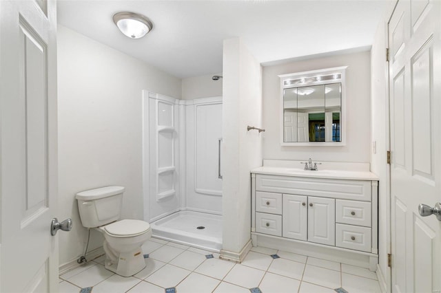 bathroom featuring vanity, tile patterned flooring, toilet, and walk in shower