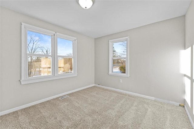 carpeted spare room featuring plenty of natural light