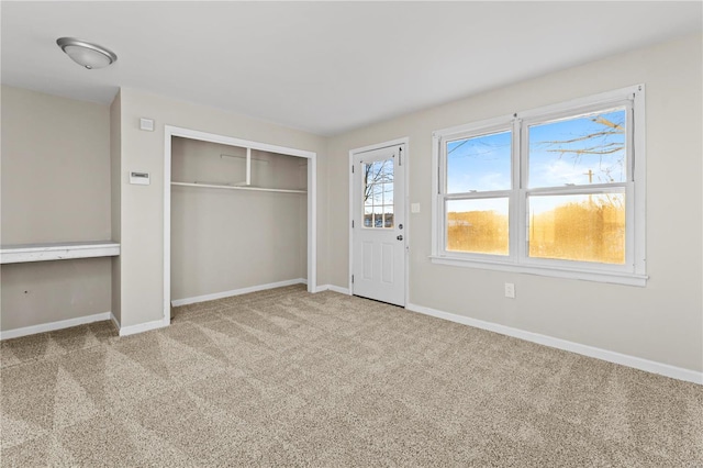 unfurnished bedroom with a closet and light carpet