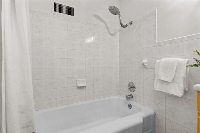 bathroom with shower / bath combo with shower curtain and tile walls