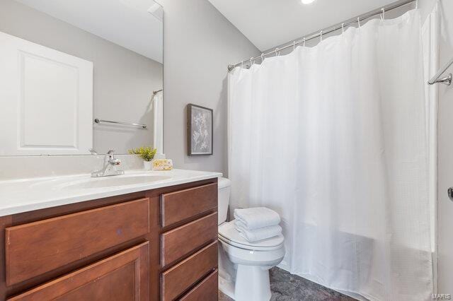 bathroom featuring vanity, toilet, and curtained shower