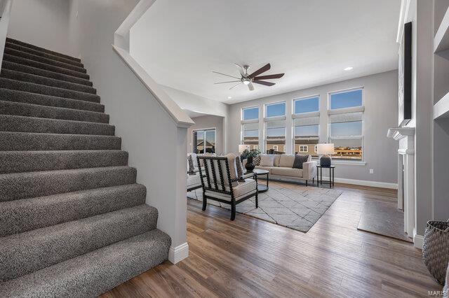 living room with wood-type flooring and ceiling fan