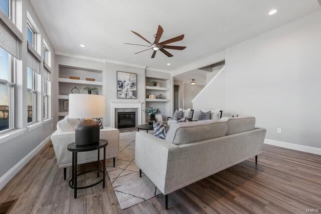 living room with hardwood / wood-style flooring, ornamental molding, ceiling fan, and built in shelves