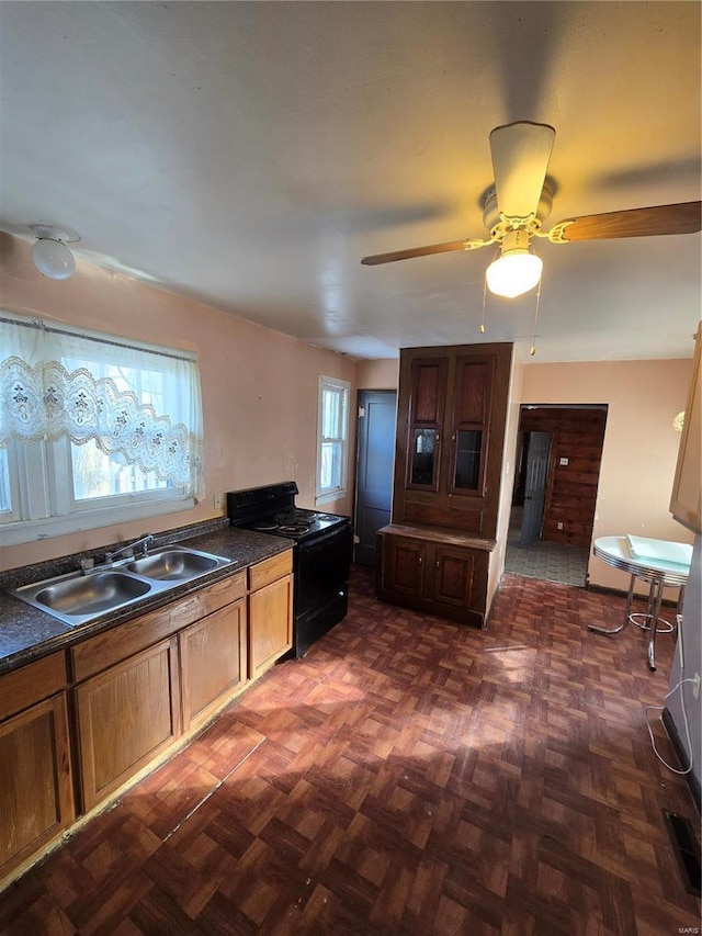 kitchen with sink, dark parquet flooring, and black range with electric stovetop