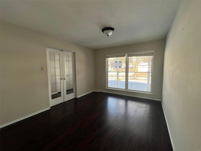 unfurnished room featuring dark wood finished floors, french doors, and baseboards