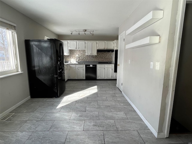 kitchen featuring black appliances, under cabinet range hood, white cabinets, decorative backsplash, and baseboards